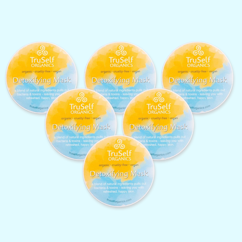 Five detoxifying mask jar lids with TruSelf Organics yellow-blue labels