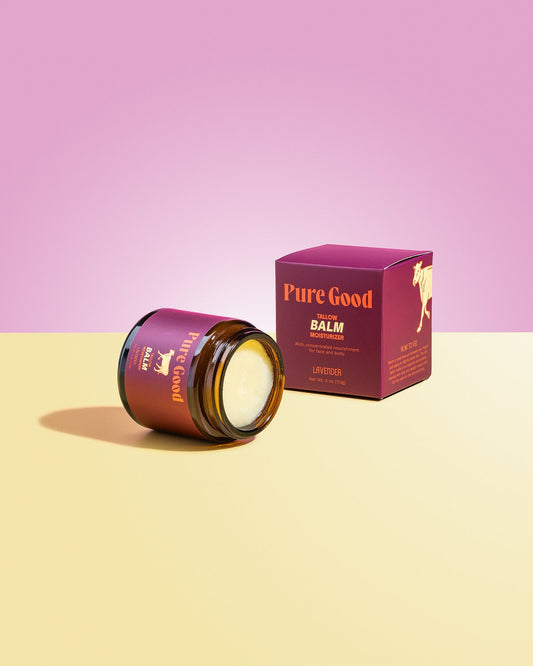 Tallow balm jar with open lid and pale cream balm, next to lavender box