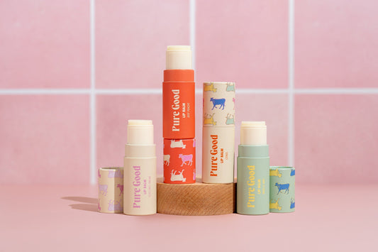 Tallow lip balm assortment in stacked tubes, including orange, green, and cream Pure Good labels