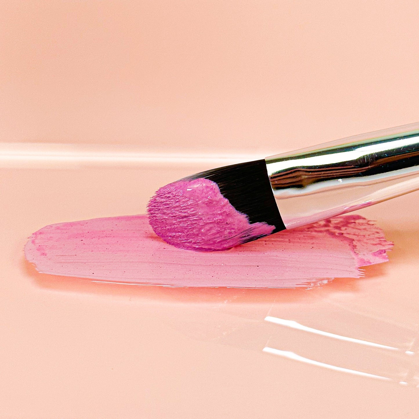 Clay face mask paste swabbed with brush, pink textured spread