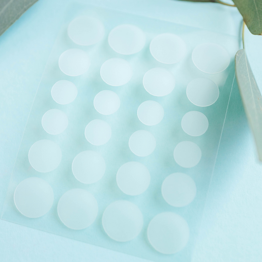 Hydrocolloid acne patches sheet with round white patches arranged in rows