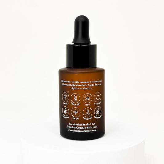 Face oil bottle with black dropper, back label side shown on amber glass