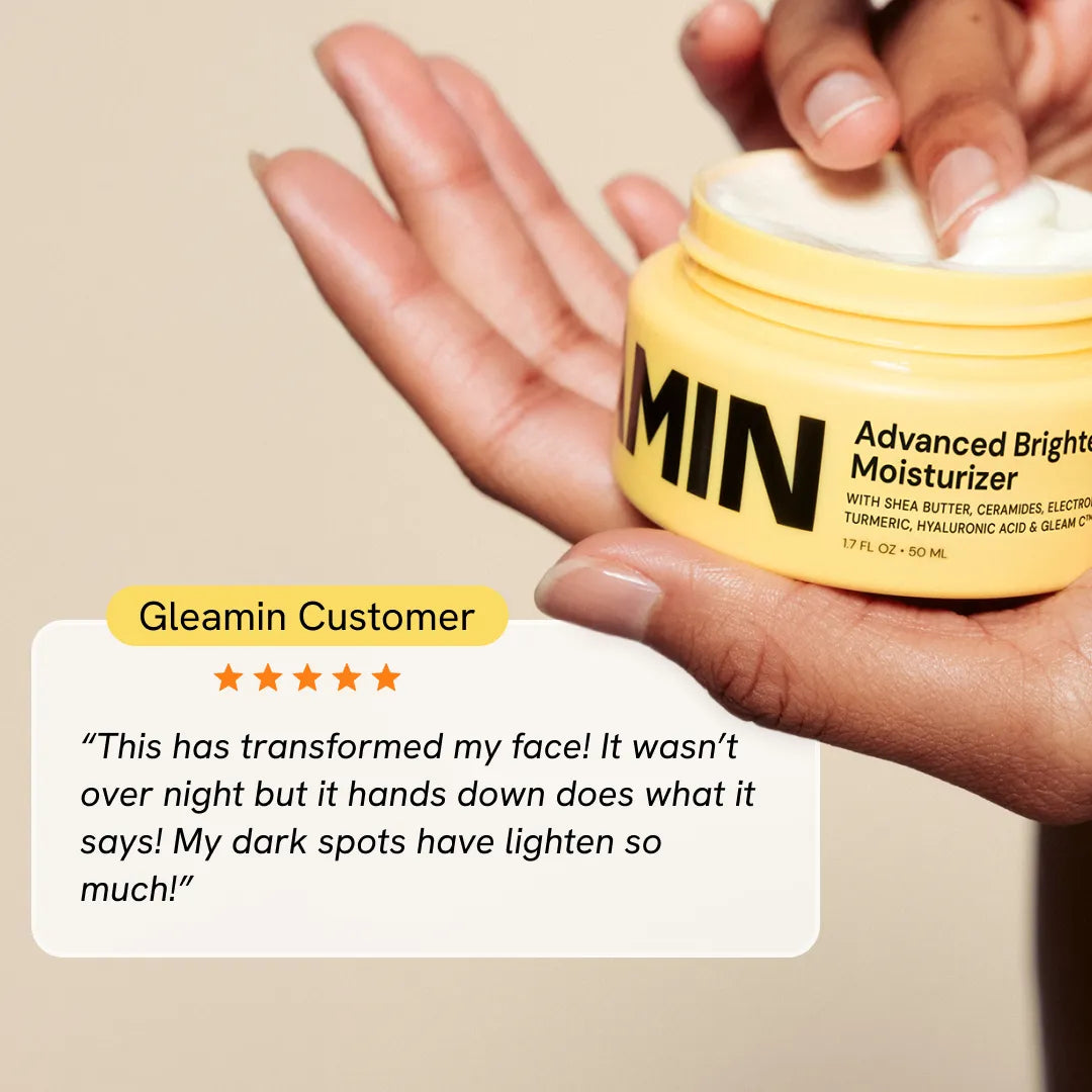 Yellow Gleamin face moisturizer jar held in hand, with silver lid and product label