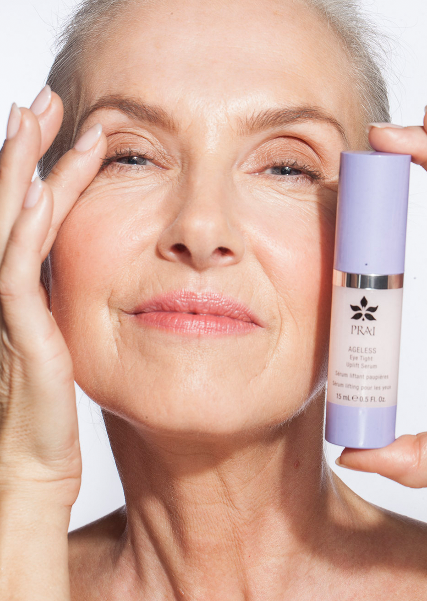 Eye area serum bottle held beside woman's eye and eyebrow