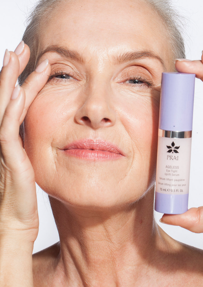 Eye area serum bottle held beside woman's eye and eyebrow