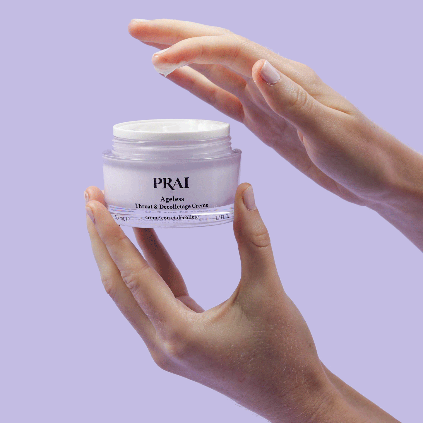 Hands holding PRai Ageless throat & décolletage crème jar