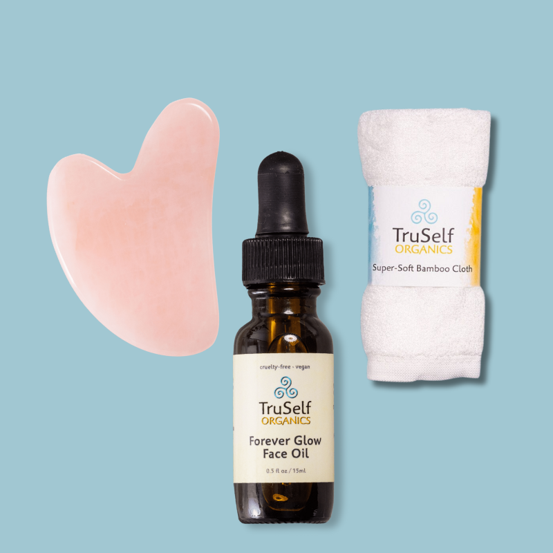 Anti-aging facial massage kit with rose quartz gua sha, face oil bottle, and bamboo cloth