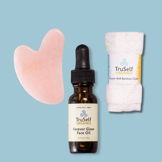 Anti-aging facial massage kit with rose quartz gua sha, face oil bottle, and bamboo cloth