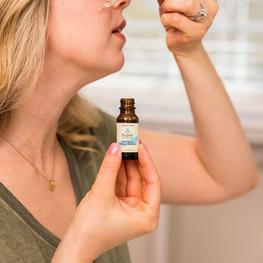 TruSelf Organics anti-aging makeup remover oil bottle held in hands