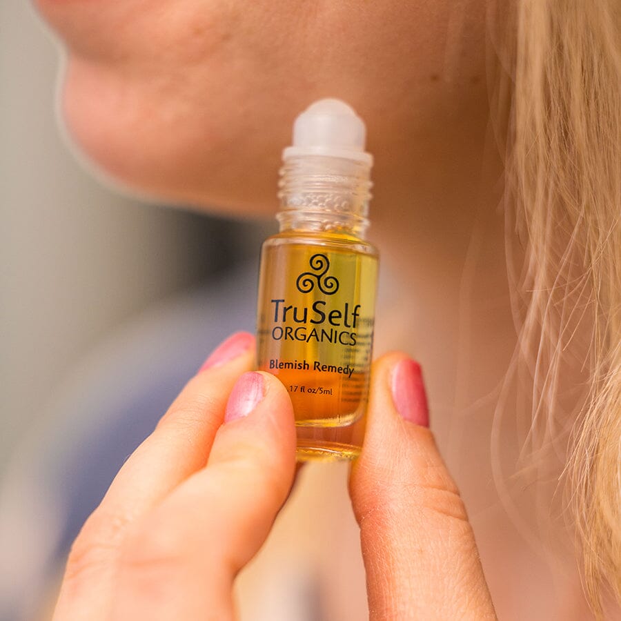 TruSelf ORGANICS blemish remedy spot treatment bottle held in hand, white cap.