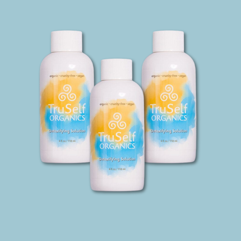 Detoxifying solution bottles set of three, white with orange-blue swirl labels and ribbed caps