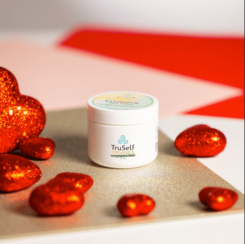 Exfoliating face polish jar with open lid, white container and beige scrub