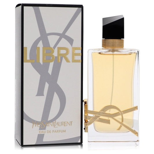 Eau de parfum spray in clear glass bottle with gold cap and gold ribbon emblem, boxed