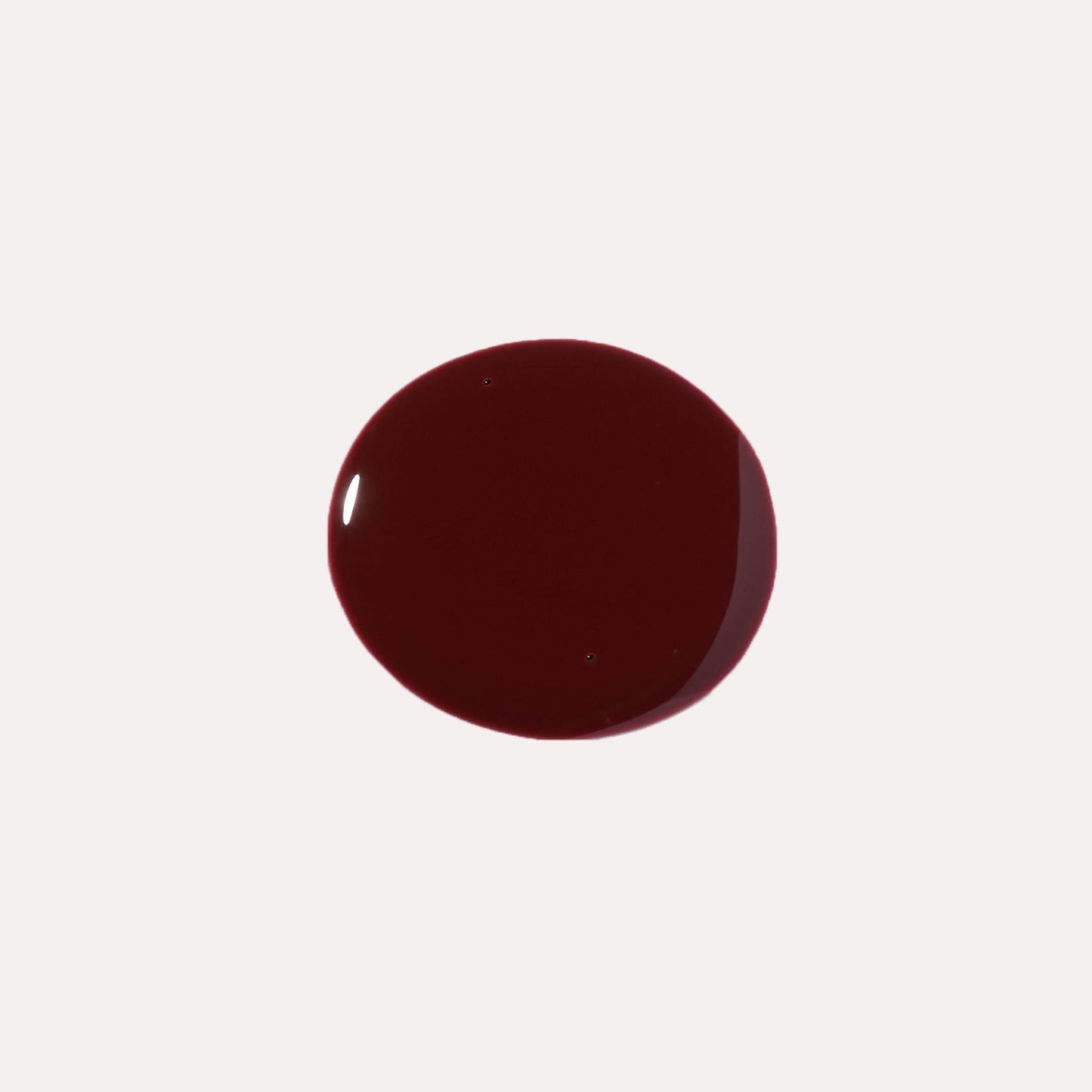 Dark maroon glossy lip oil drop swatch on light background