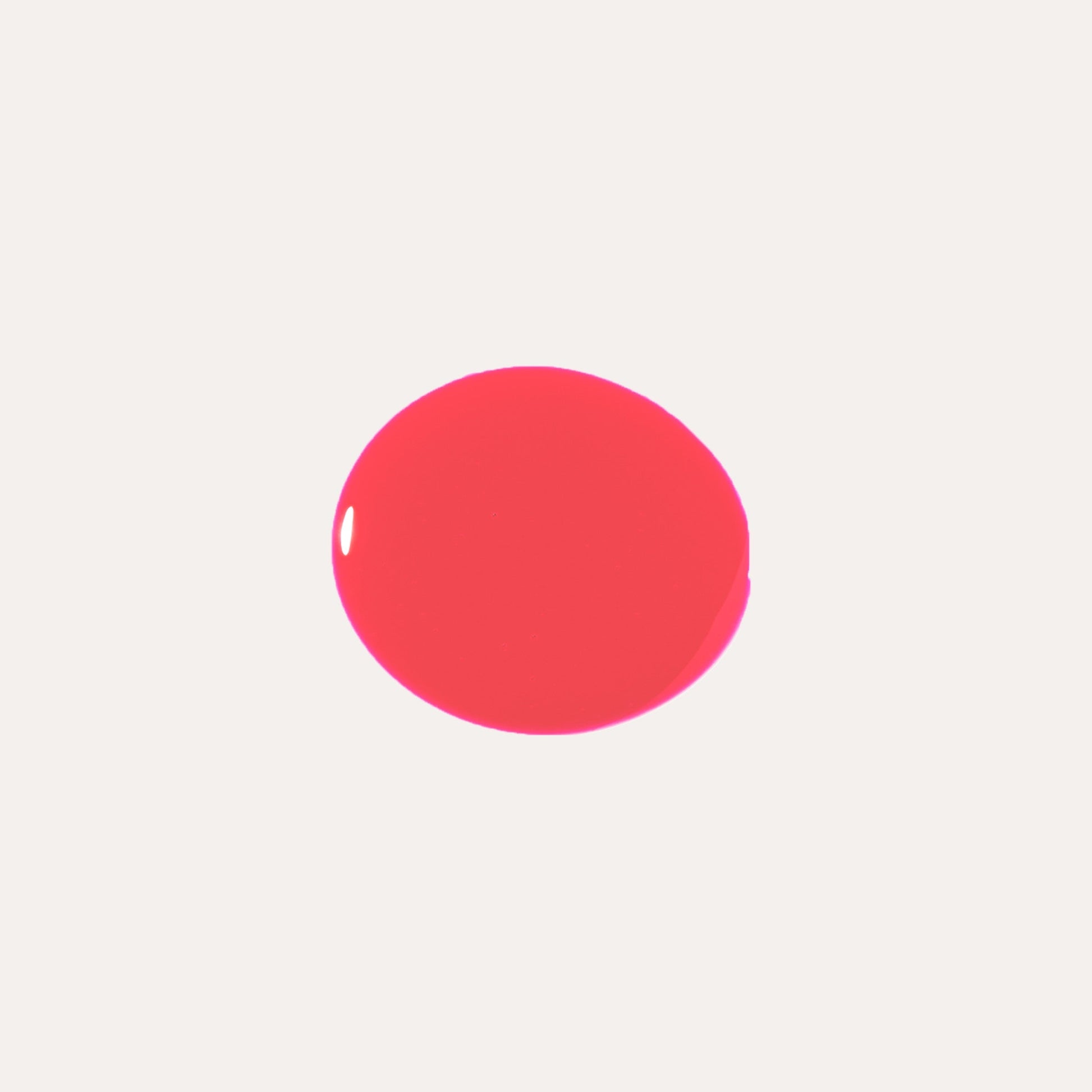 Bright red-pink glossy lip oil swatch circle