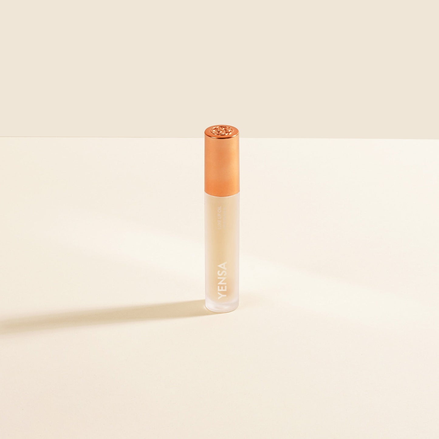 YENSA lip oil bottle with rose-gold cap, clear gel formula