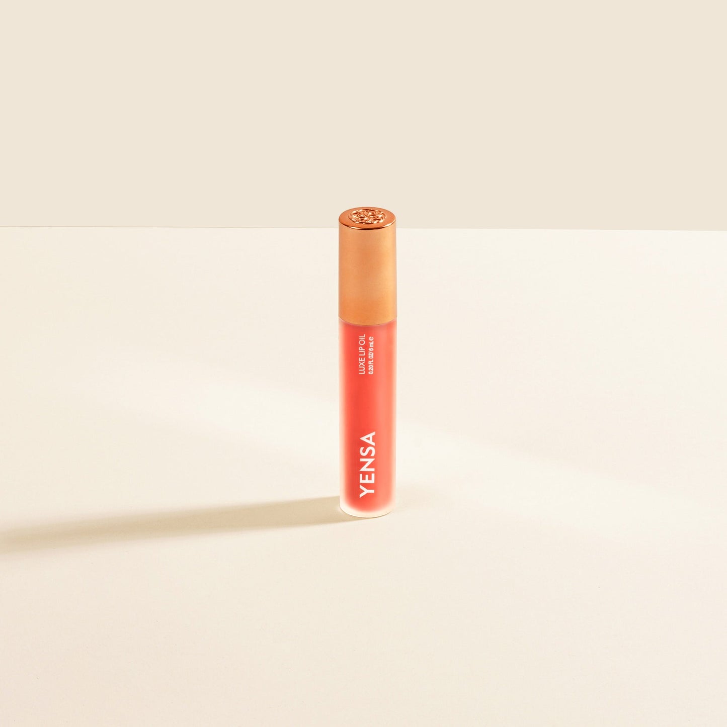 Coral-red lip nourishing oil tube with gold cap and YENSA branding