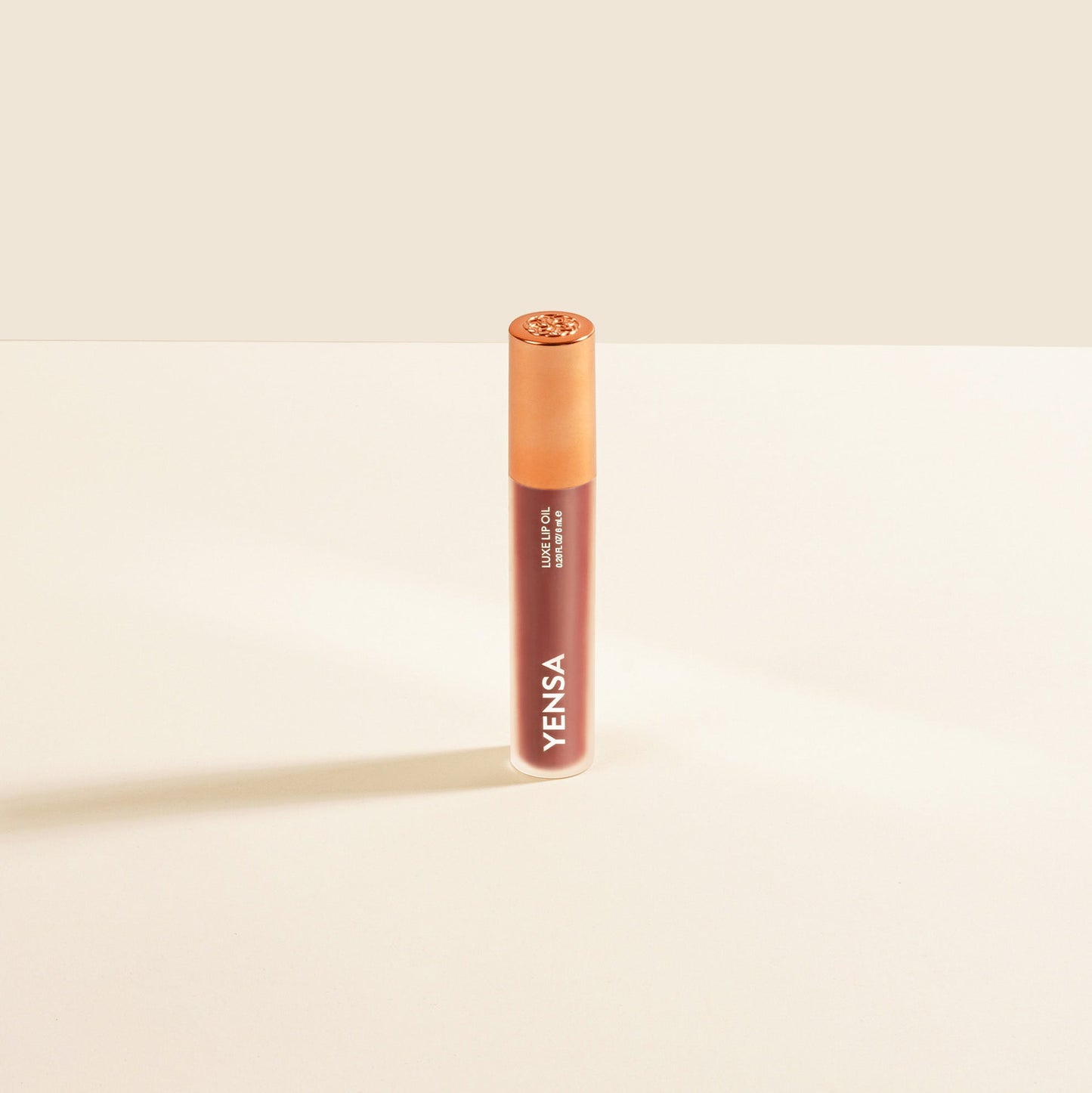 Lip nourishing oil tube with gold cap and maroon body, labeled YENSA
