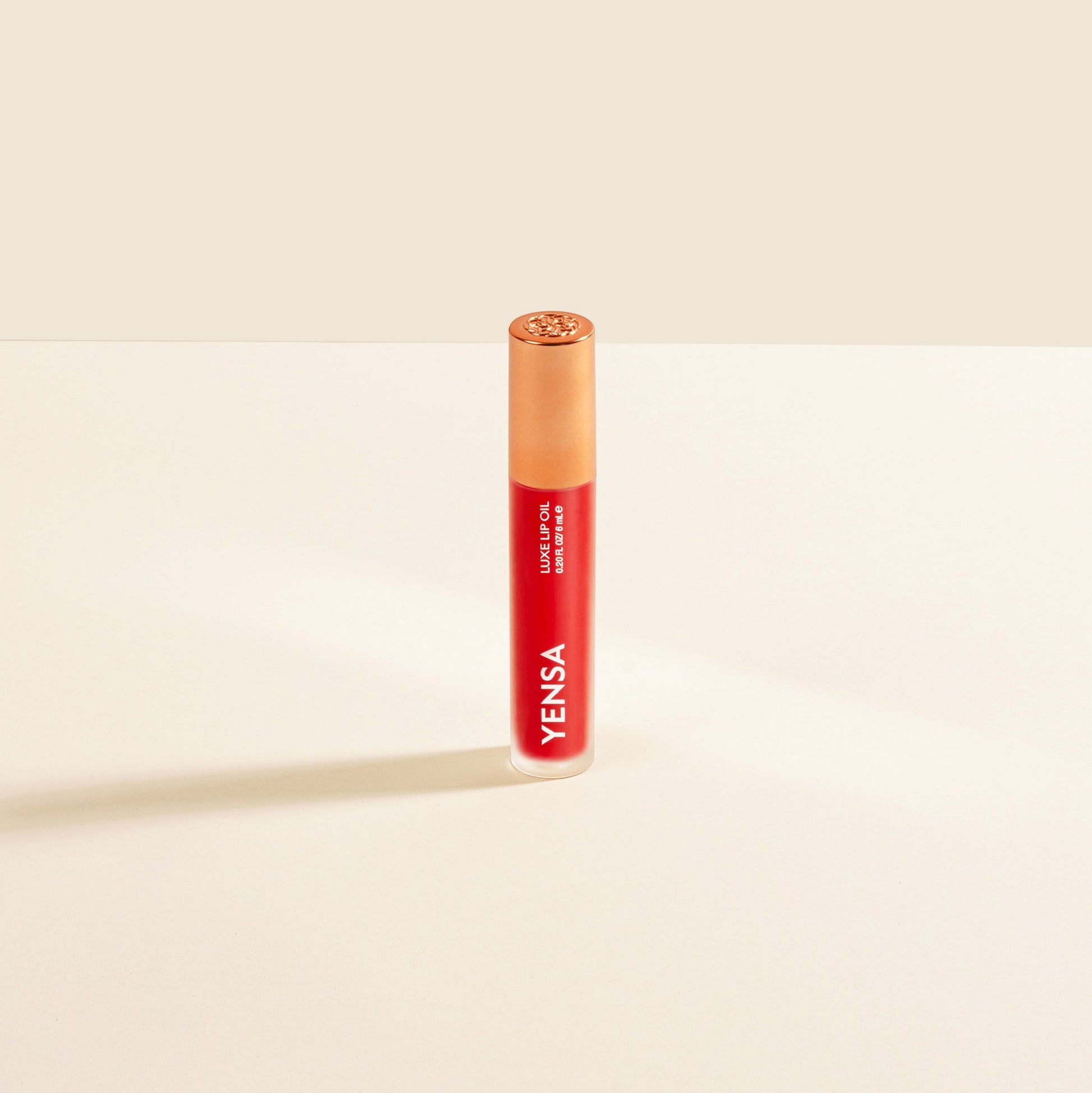 Red lip nourishing oil in clear tube with gold cap and YENSA label