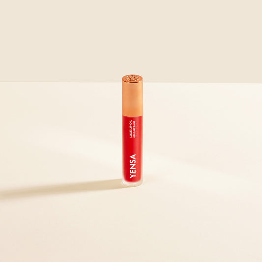 Red lip nourishing oil in clear tube with gold cap and YENSA label