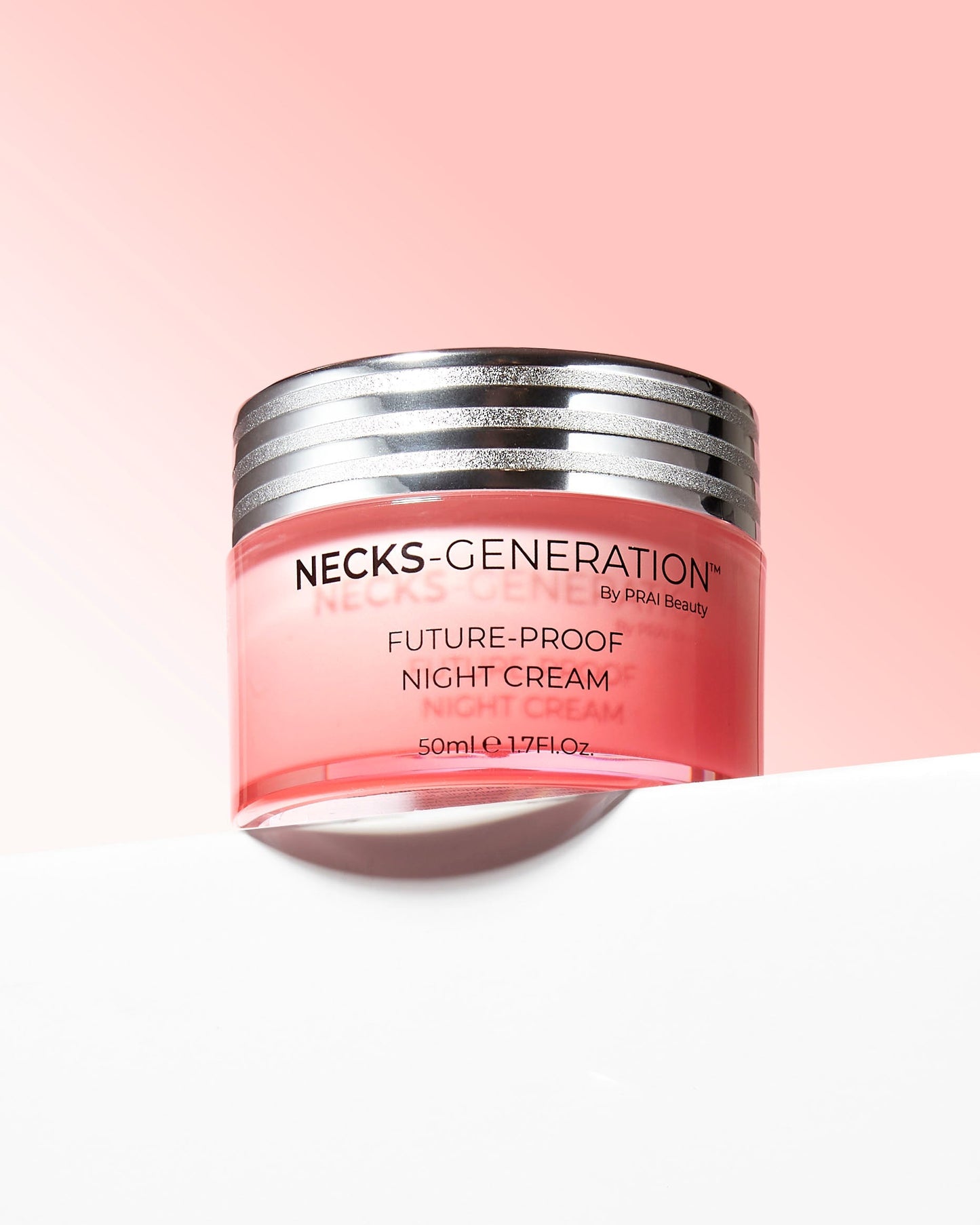 Pink night cream jar with silver ridged lid, shown at an angle, 50ml