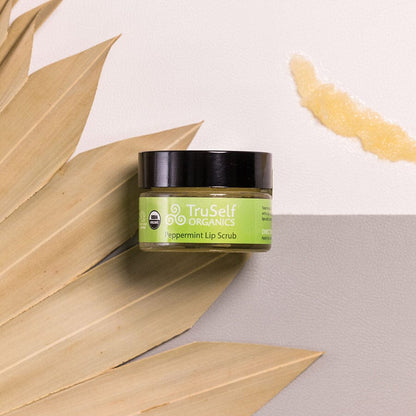 Lip scrub jar: TruSelf ORGANICS peppermint scrub with black lid and green label.