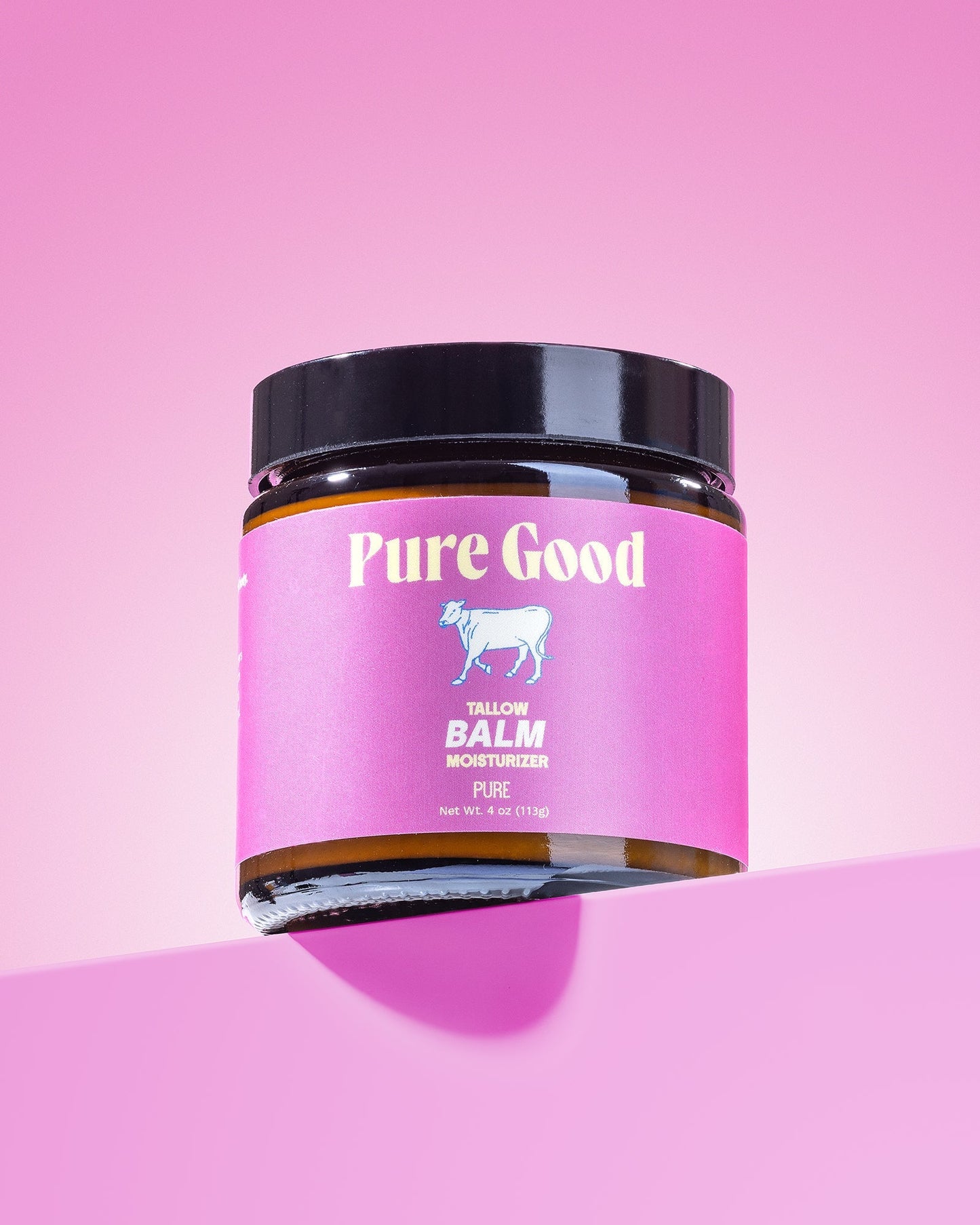 Tallow balm jar with pink label and black lid in the foreground