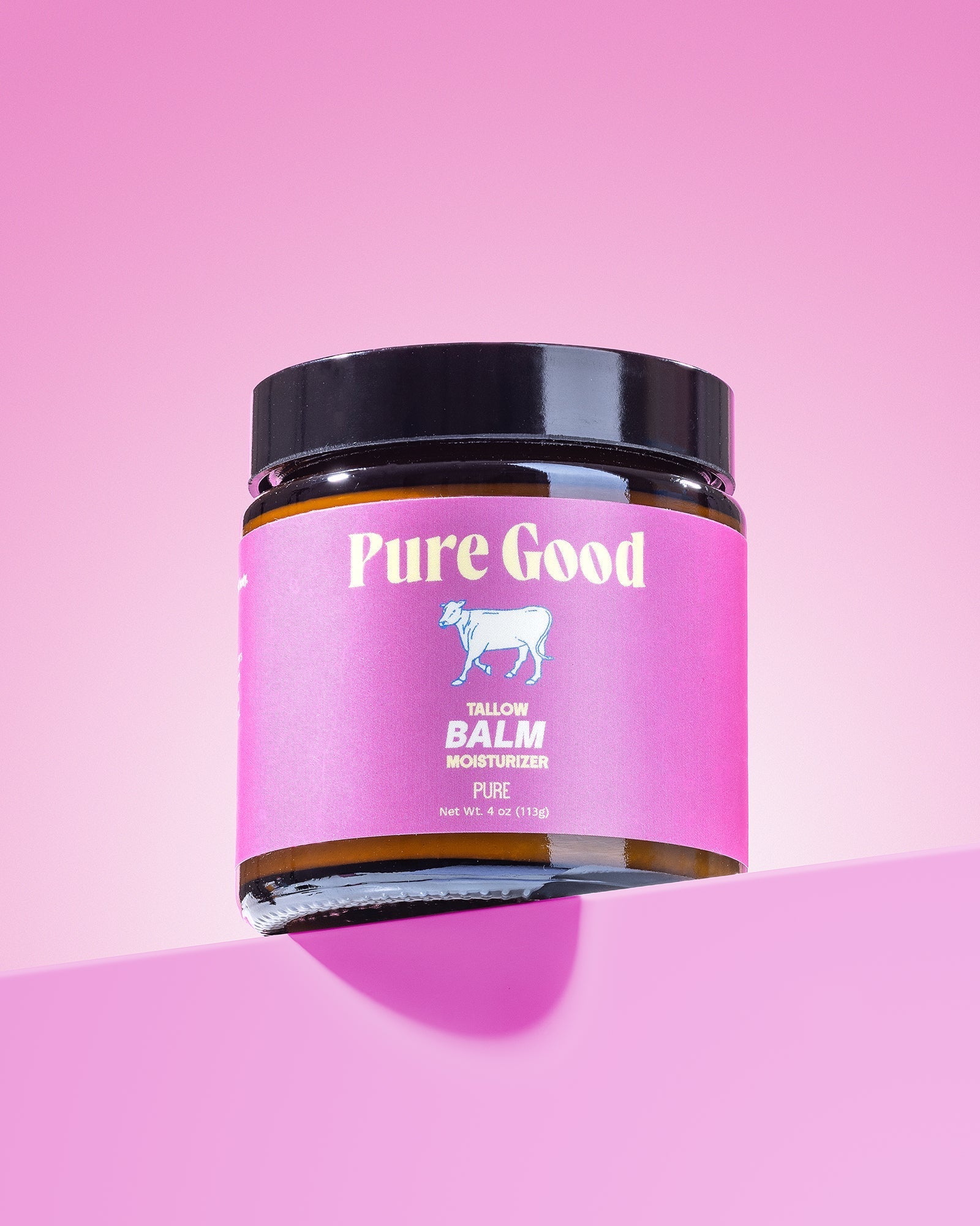 Tallow balm jar with pink label and black lid in the foreground