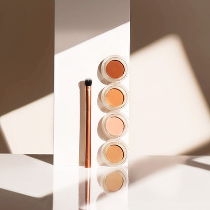 Under-eye serum jar with rose-gold lid, creamy corrector product inside