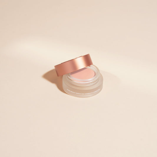 Under-eye serum jar with rose-gold lid, creamy corrector product inside