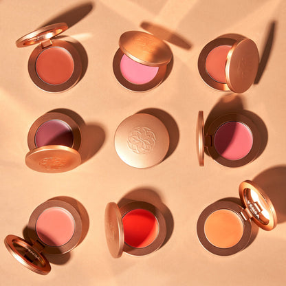 Cream blush compacts with gold cases, showing pink and coral round pans