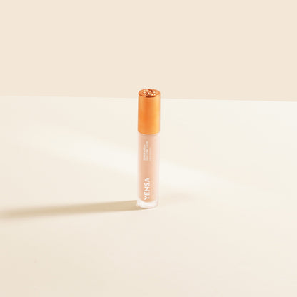 Silk concealer serum bottle with copper cap and light peach liquid