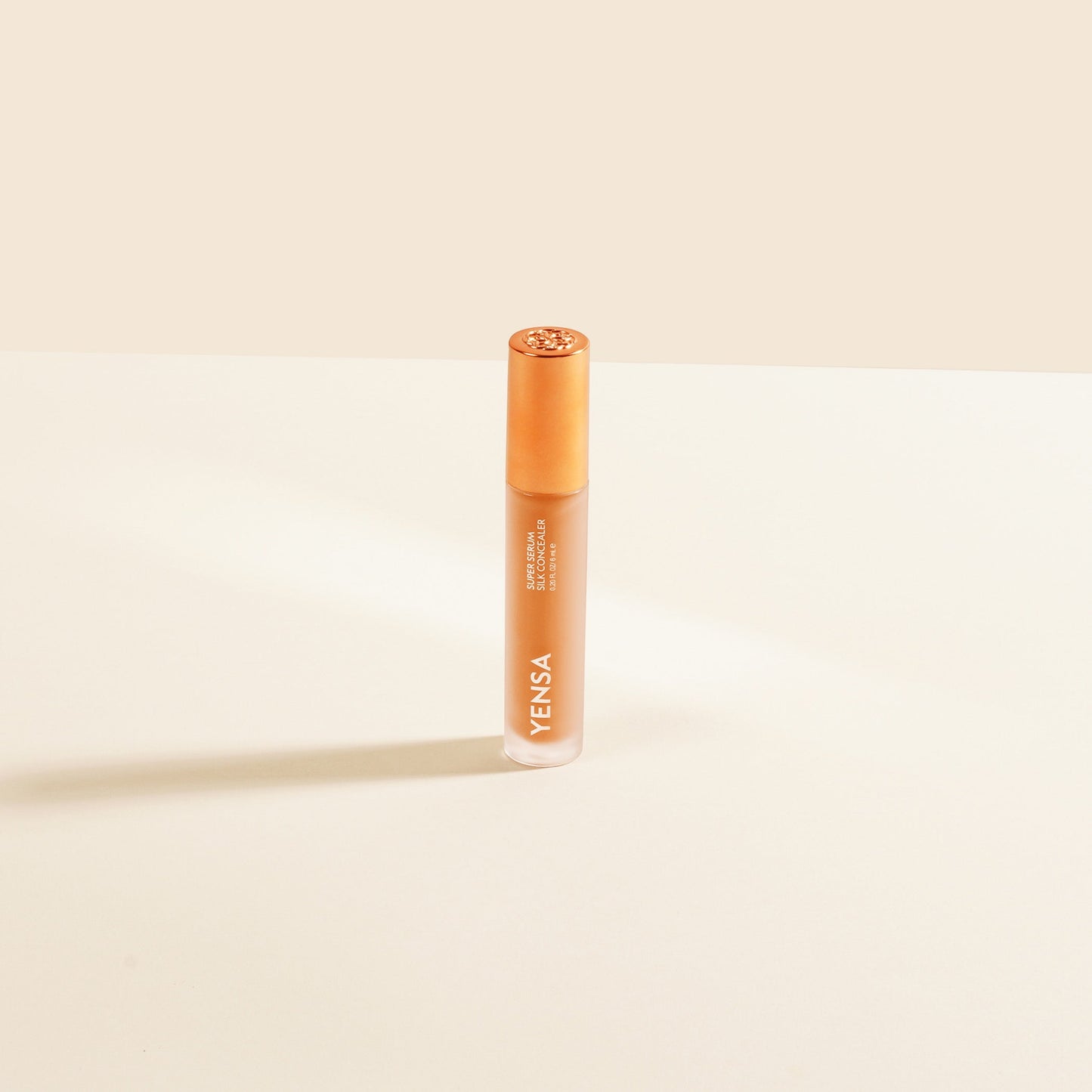 YENSA Super Serum Silk Concealer tube with orange cap, light peach liquid