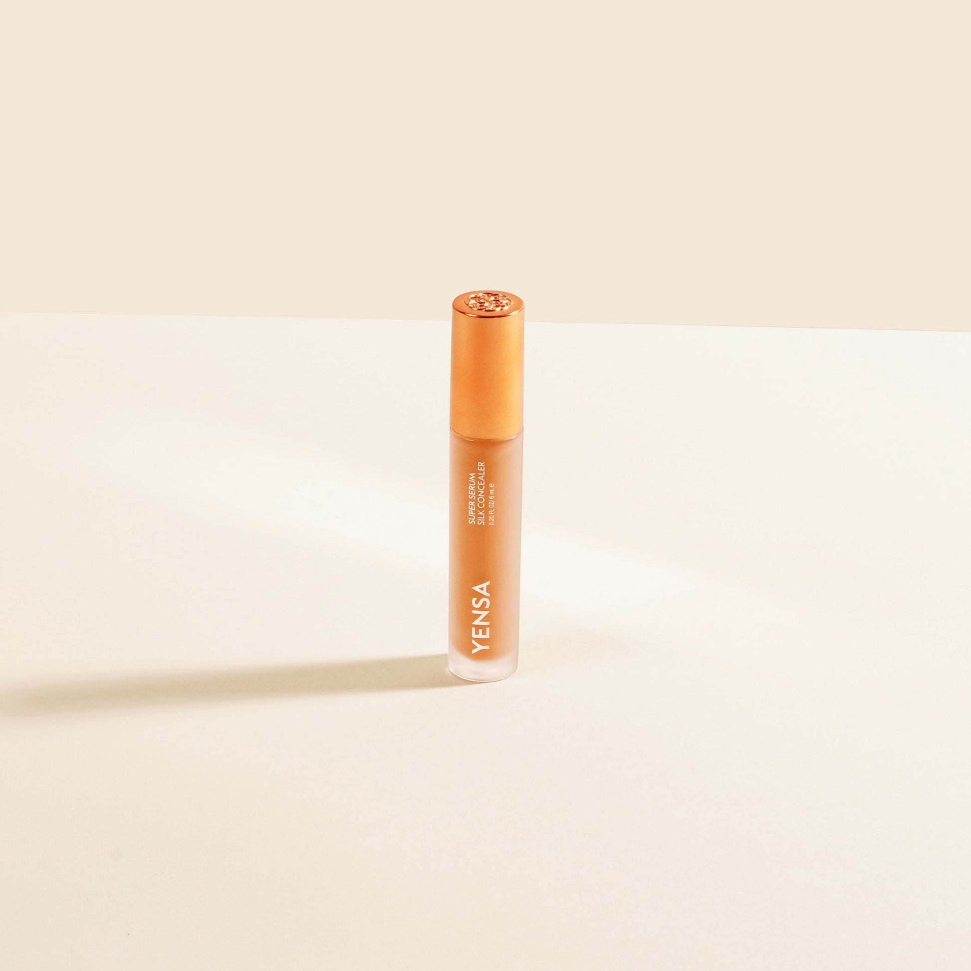 YENSA Super Serum Silk Concealer tube with orange cap, light peach liquid