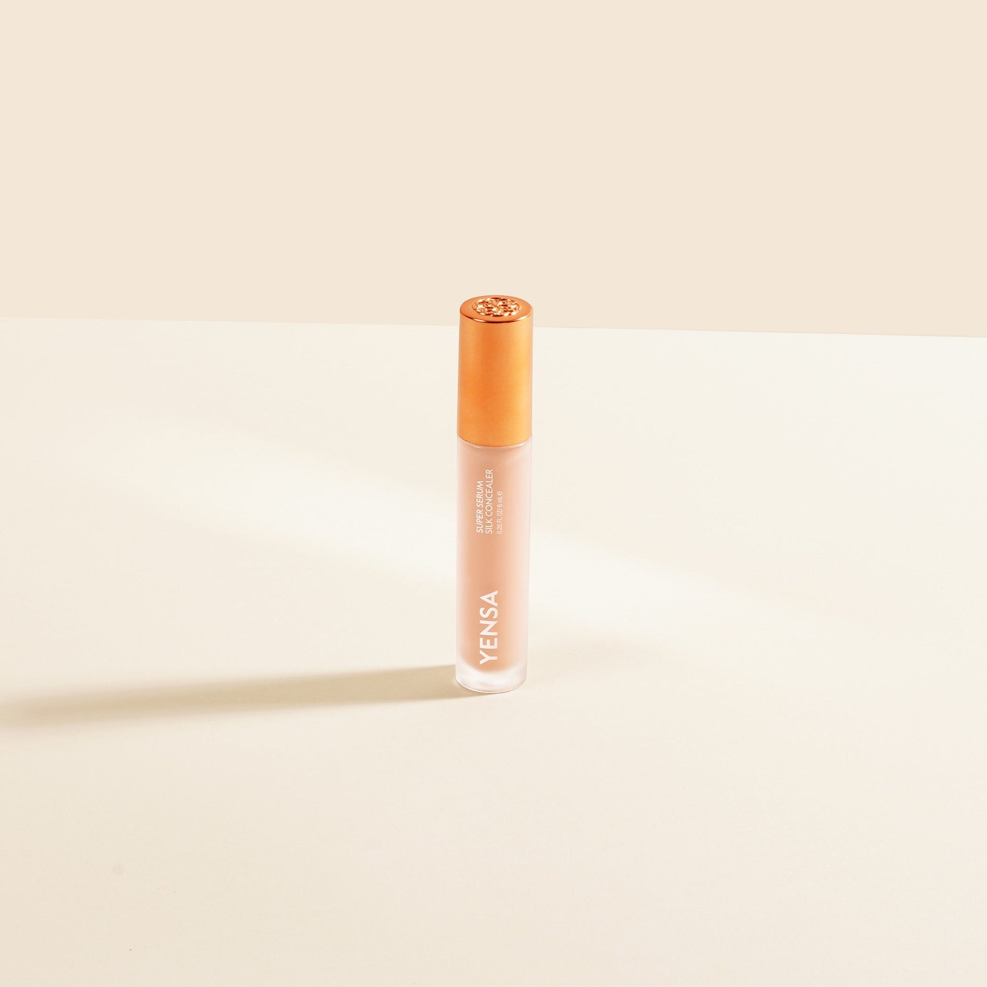 Silk concealer serum bottle with copper cap and beige-toned liquid