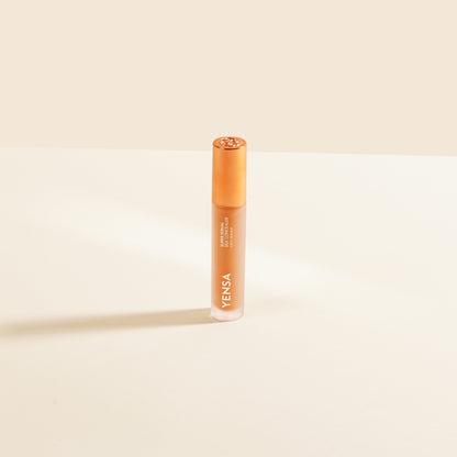 Concealer tube with rose-gold cap, light peach liquid shade