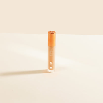 Concealer tube with rose-gold cap, light peach liquid shade