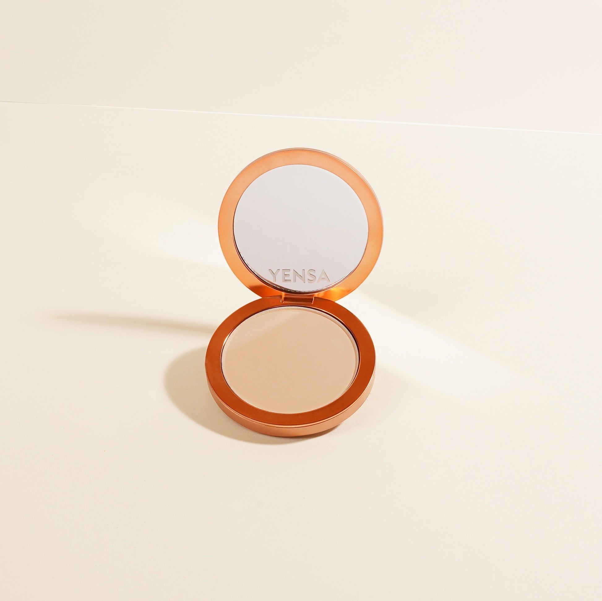 Opened compact powder foundation, light beige shade in round pan