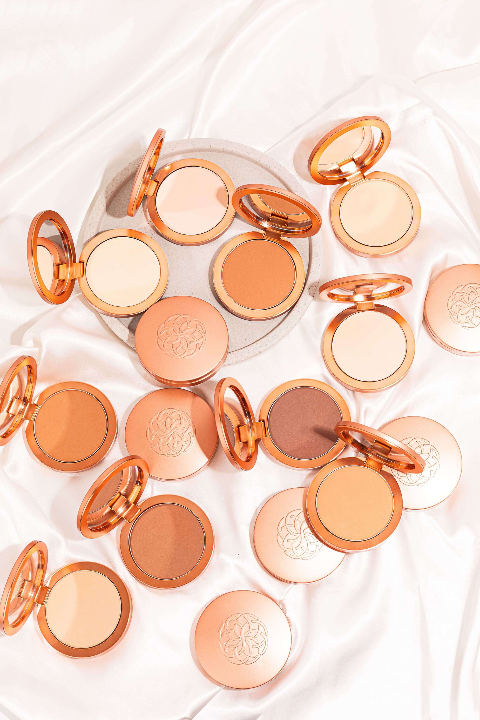 Assorted compact powder foundations arranged with open circular pans