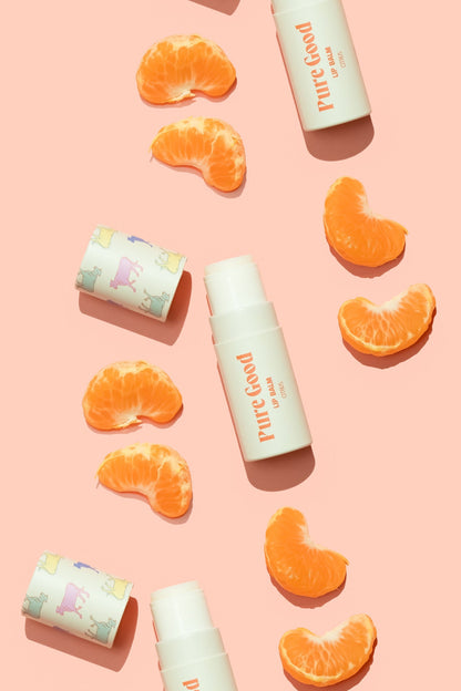 Tallow lip balm with orange flavor tube and orange wedges arranged around it