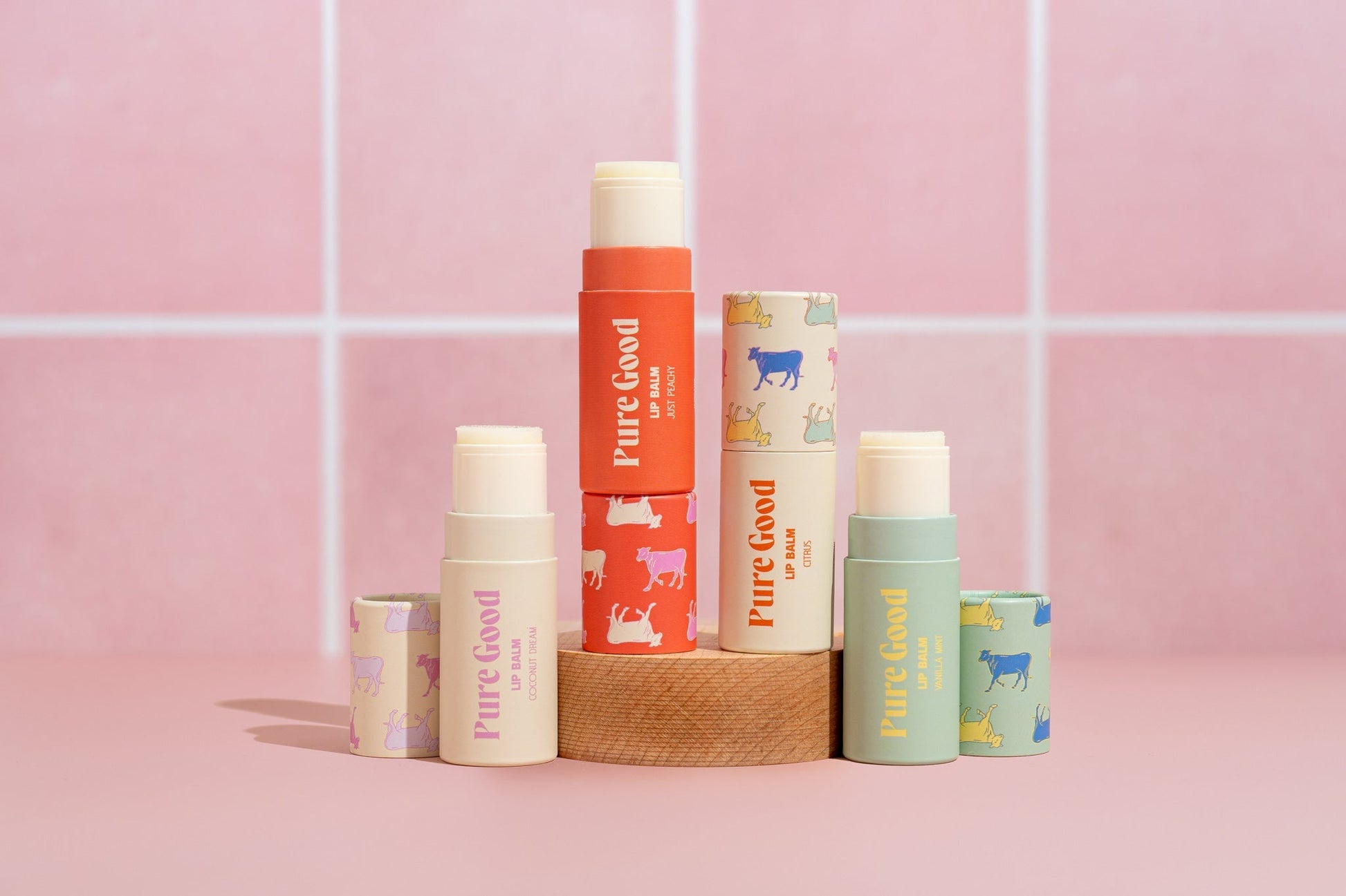 Tallow lip balm assortment in stacked tubes, including orange, green, and cream Pure Good labels