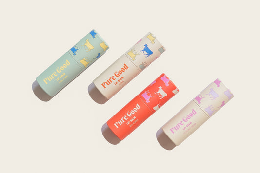 Tallow lip balm tubes in mint, cream, coral orange, and pale purple with Pure Good labels