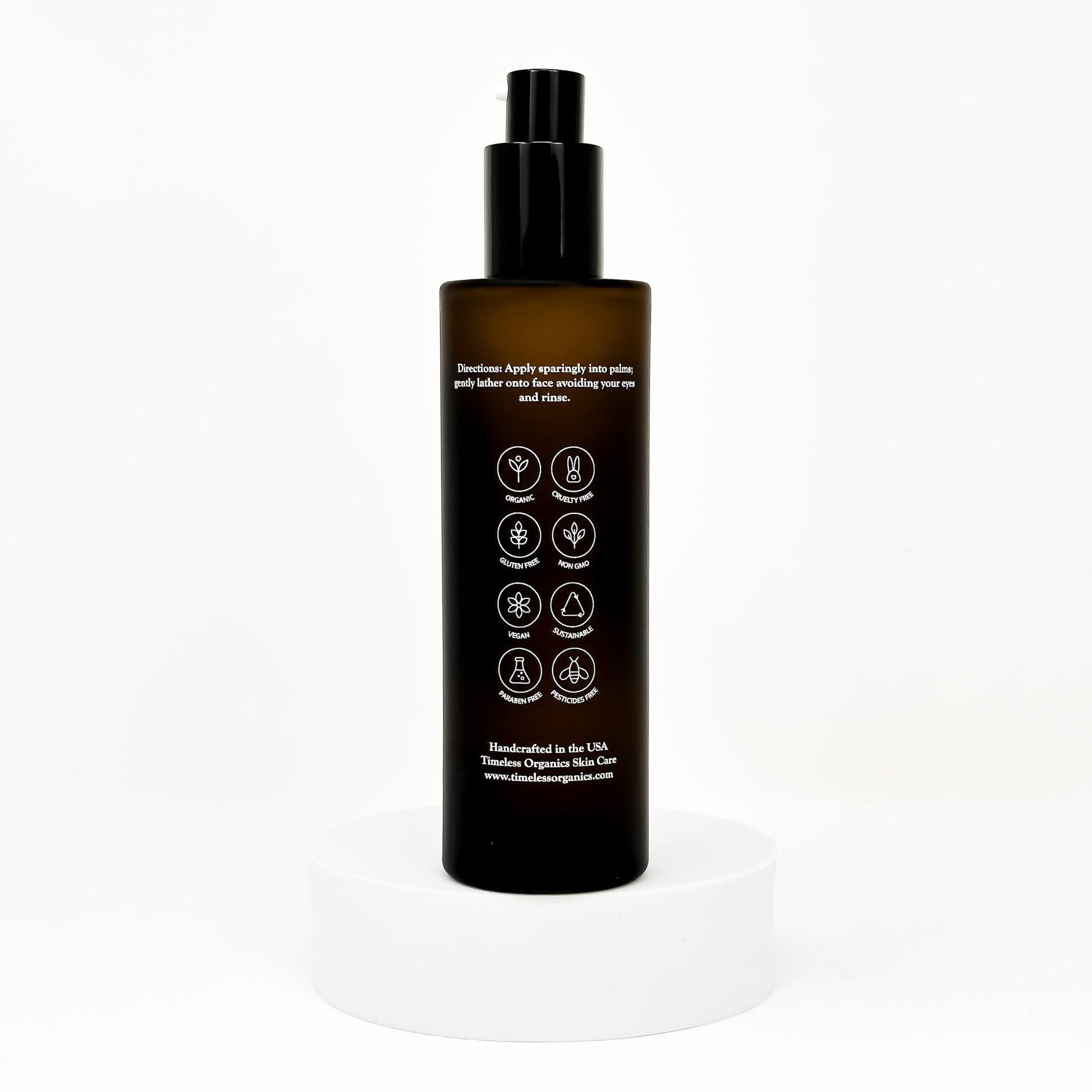 Anti-aging facial cleanser bottle with black pump, back label with icons and directions