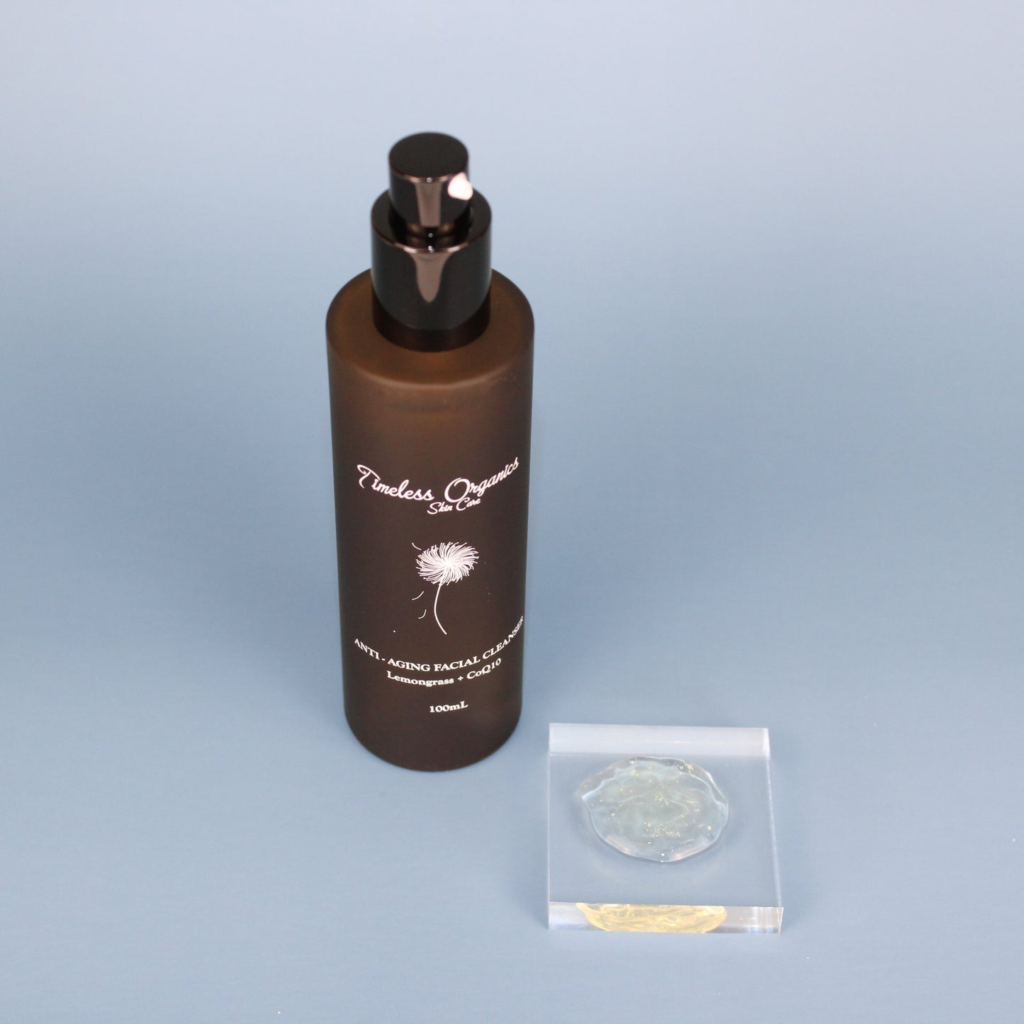 Anti-aging facial cleanser bottle with black pump and small clear sample packets