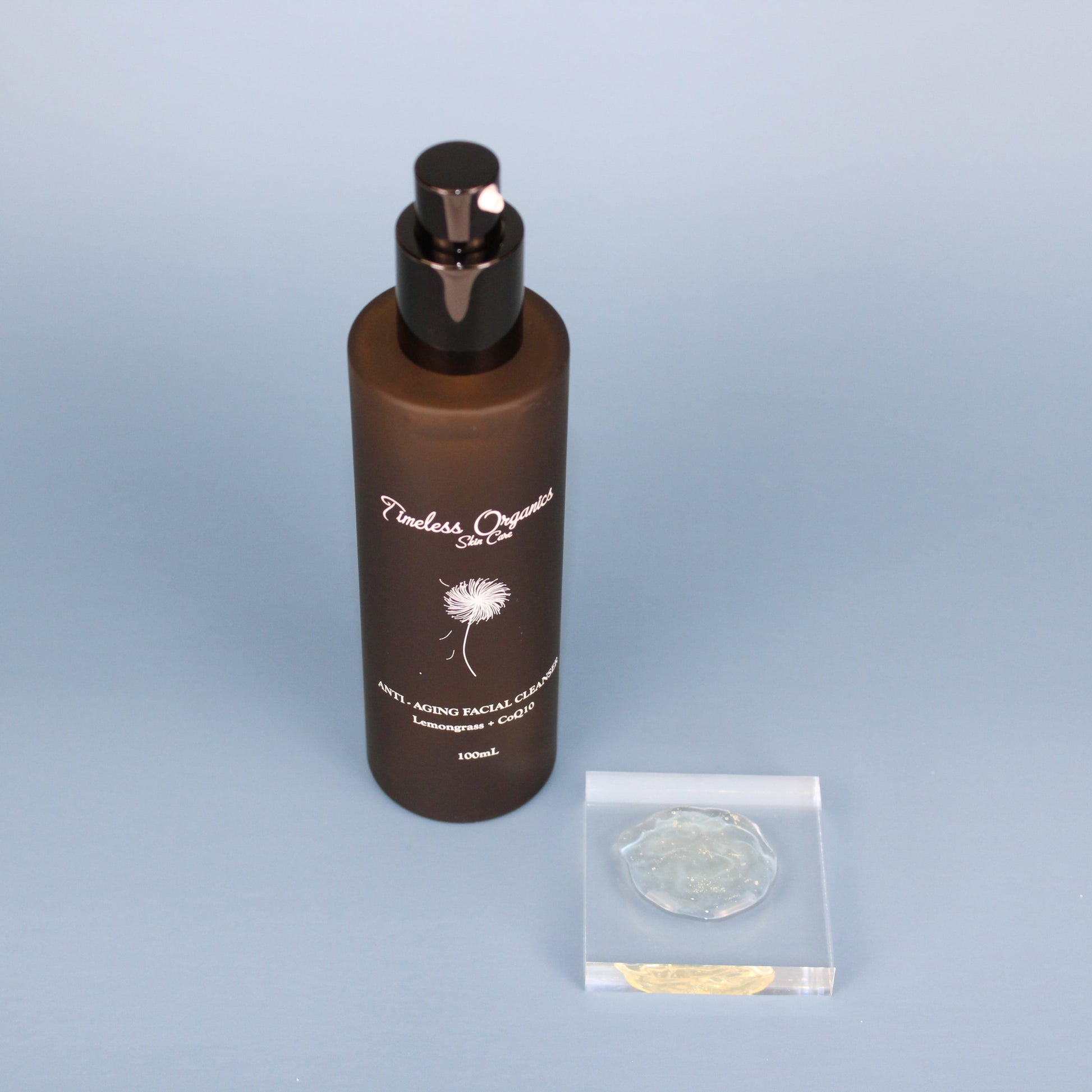 Anti-aging facial cleanser bottle with black pump and small clear sample packets