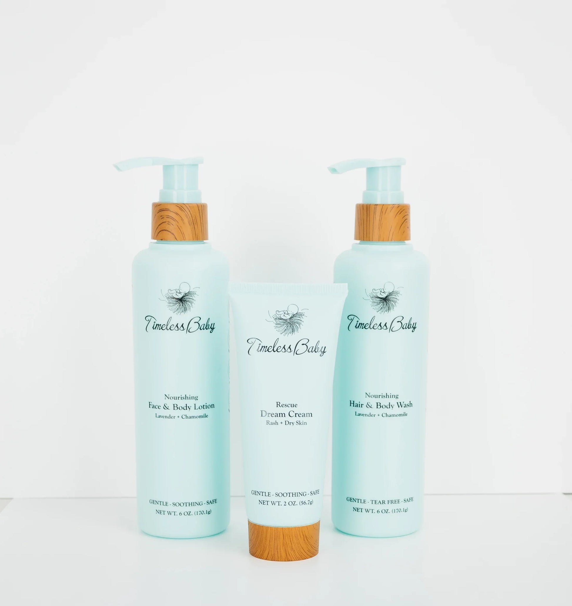 Baby skincare set: two light blue pump bottles and a cream tube with bamboo caps