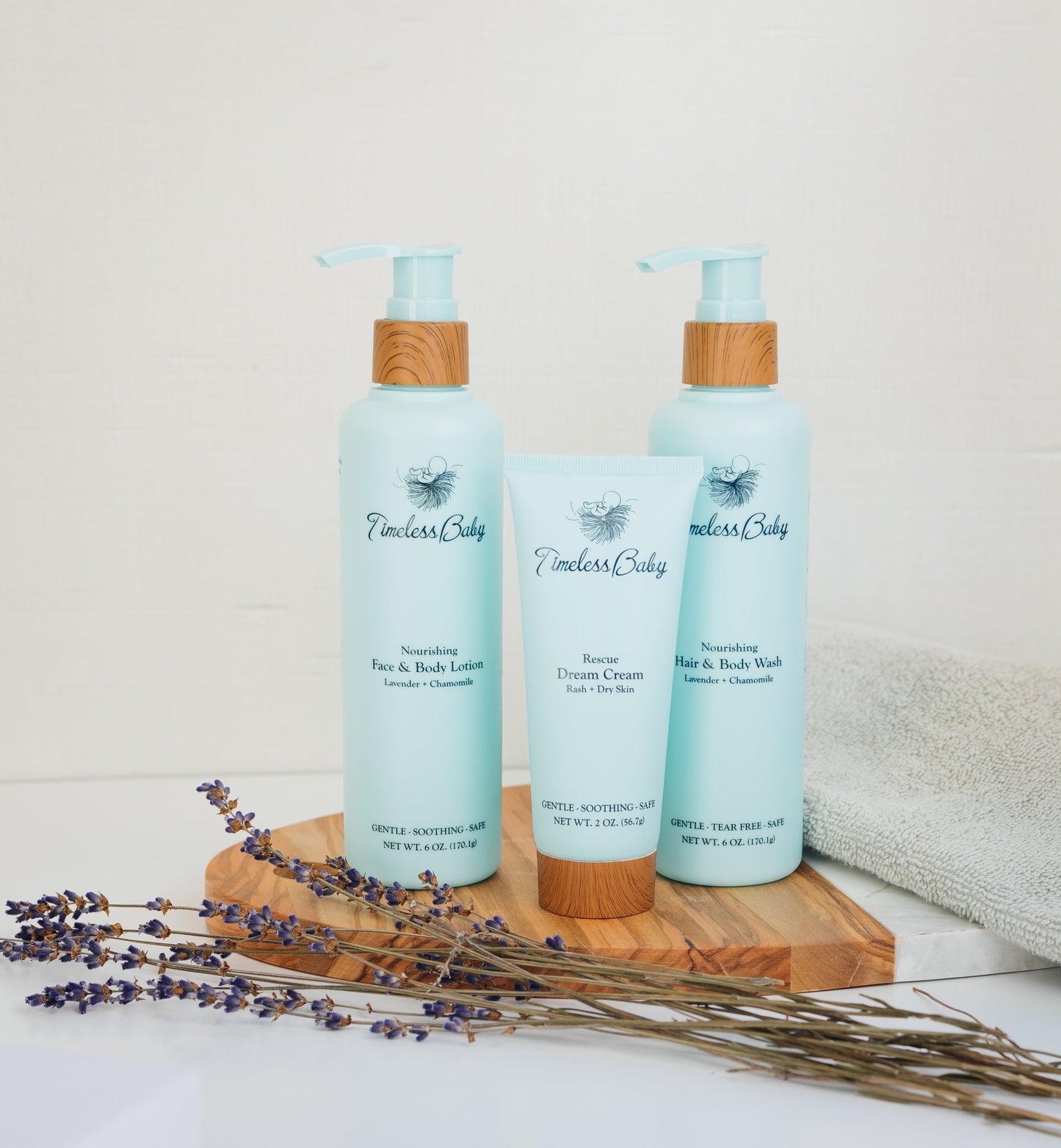 Baby skincare set with two light blue pump bottles and a cream tube, bamboo caps