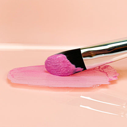 Clay face mask paste swabbed with brush, pink textured spread