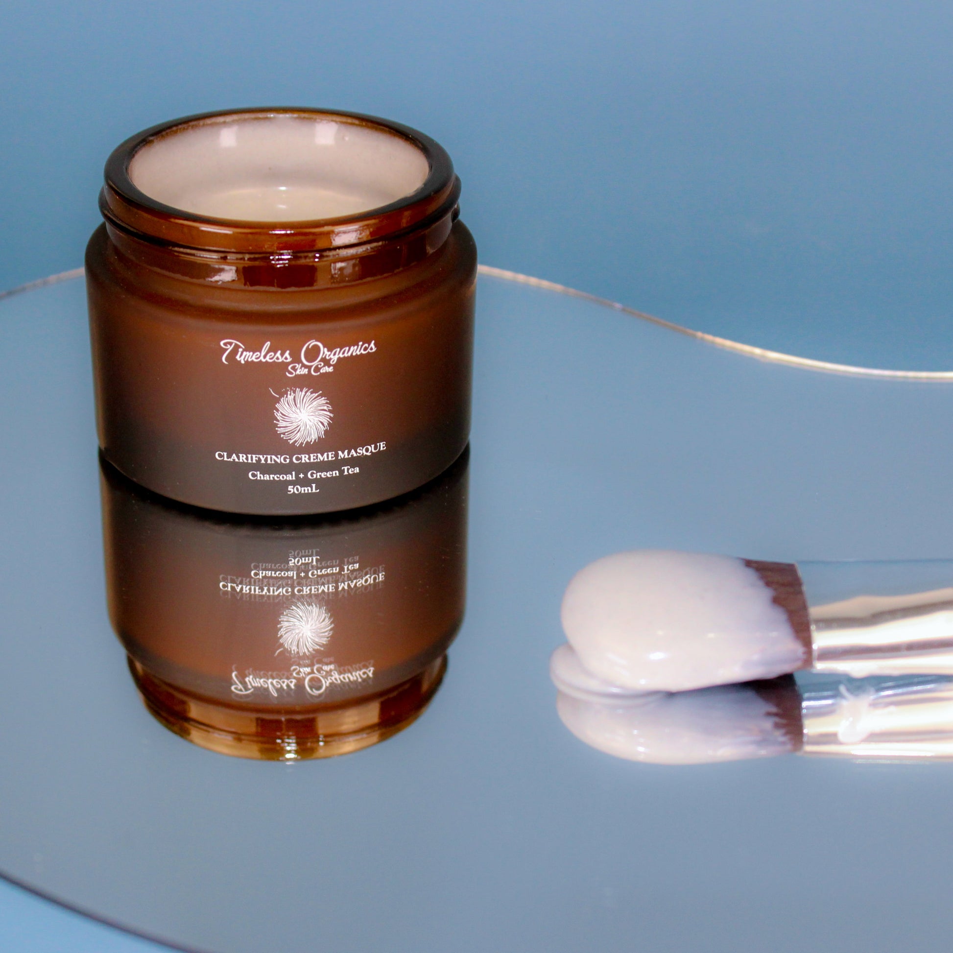 Timeless Organics clarifying cream masque jar with cream on applicator spoon