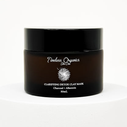 Black clay face mask jar with gold label text and flip-top lid